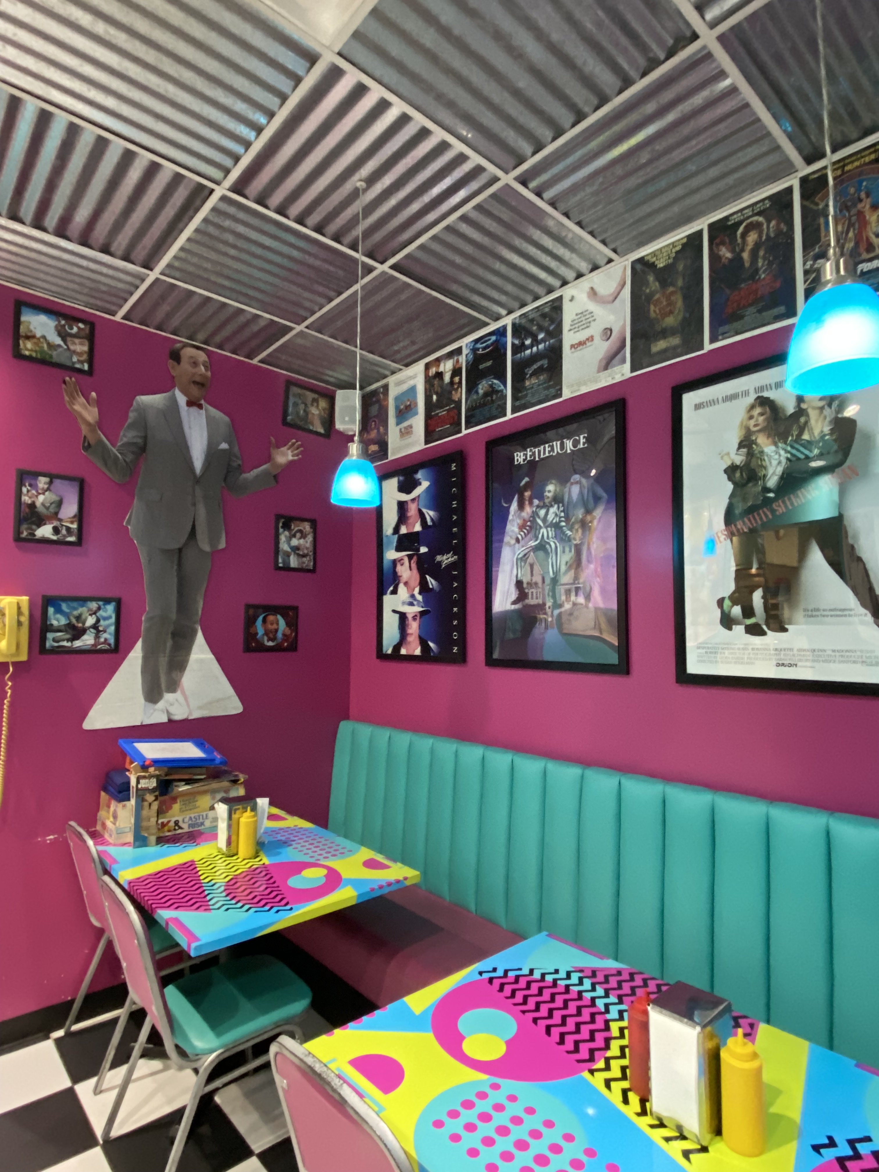 80年代的咖啡馆用餐区有80年代的纪念品- Pee Wee Herman, Beetlejuice, Michael Jackson和其他复古装饰